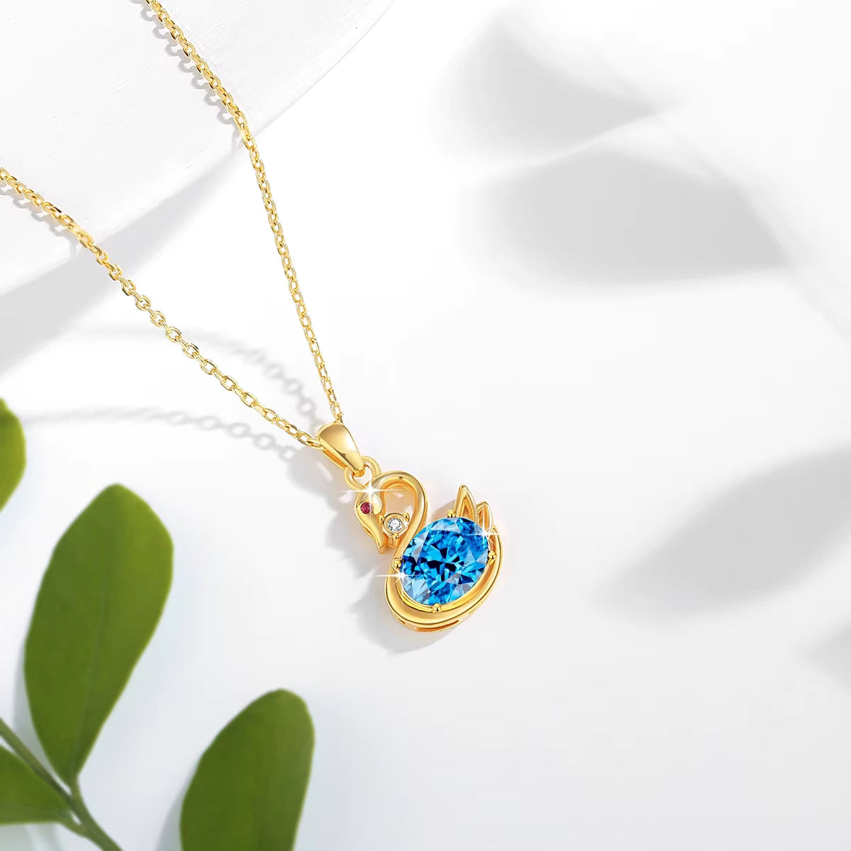 Pendentif cygne topaze radieuse en or jaune 18K orné d'un rubis et d'un diamant scintillant vue du dessus.