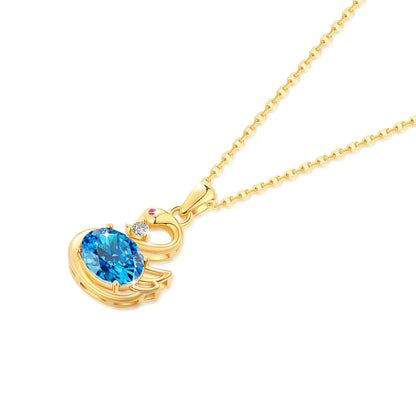 Pendentif cygne topaze radieuse en or jaune 18K rayonnant orné d'un rubis et d'un diamant à plat.