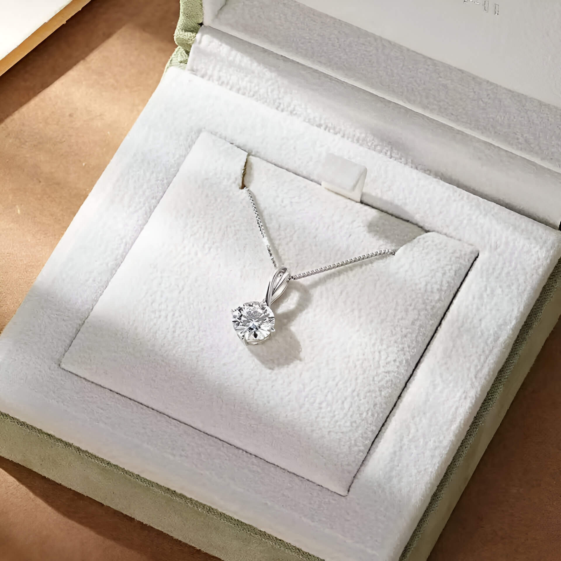 Pendentif echevêtré en argent sterling 925 plaqué or blanc et moissanite solitaire rangé dans son écrin.