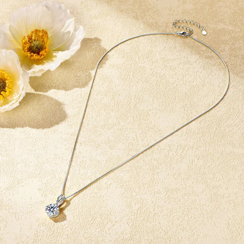 Pendentif echevêtré en argent plaqué or blanc et moissanite solitaire à plat vue en entier.