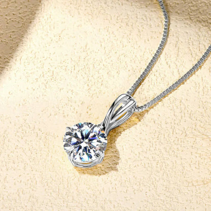 Pendentif echevêtré en argent plaqué or blanc et moissanite solitaire à plat vue de côté.