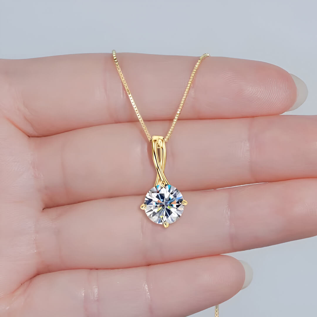 Pendentif entrelacé oriana en argent 925 plaqué or jaune et diamant solitaire sur les doigts d'une femme vue de face.