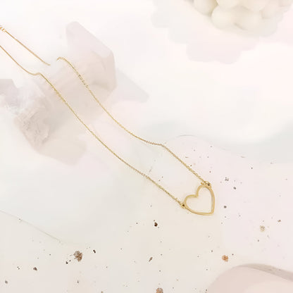 Collier pendentif fantaisie cœur en acier inoxydable plaqué or jaune à plat.