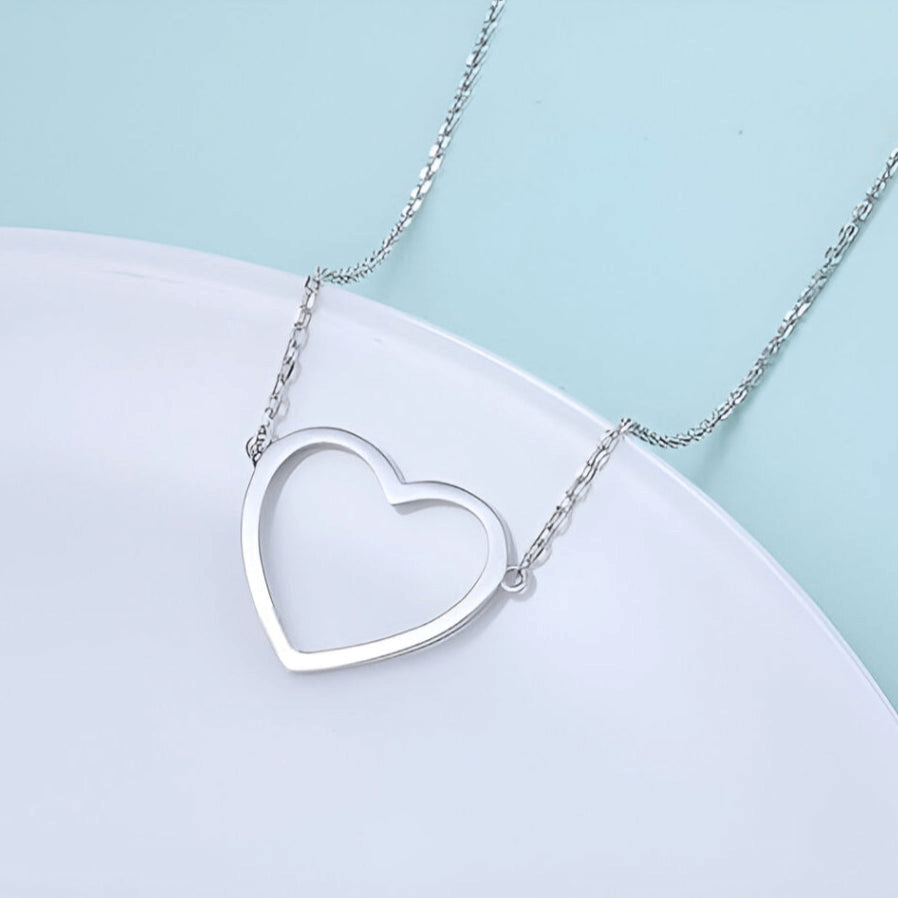 Collier pendentif fantaisie cœur en acier platiné plaqué or blanc vue de proche.