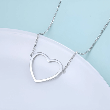 Collier pendentif fantaisie cœur en acier platiné plaqué or blanc vue de proche.