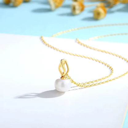 Pendentif flamme dorée Nérhi en or jaune 18K lumineux et perle naturelle nacrée vue de côté.