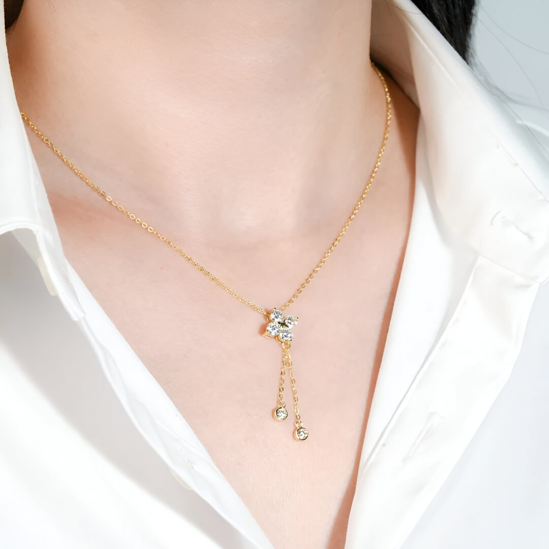 Pendentif fleur à pampilles en argent 925 plaqué or jaune et diamants porté au cou d'une femme vue de côté.