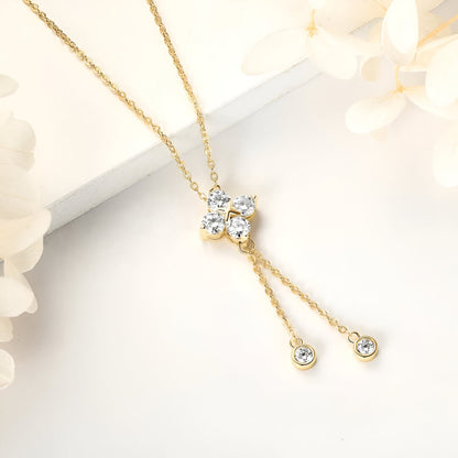 Pendentif fleur à pampilles en or jaune et diamants synthétiques posé.