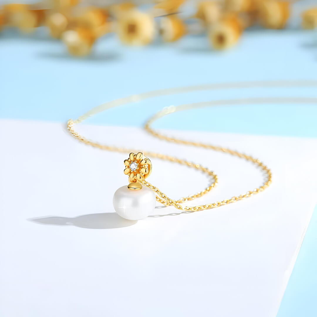 Pendentif fleur de marguerite Solénia en or jaune 18K orné d'un diamant et d'une perle naturelle nacrée vue de côté.