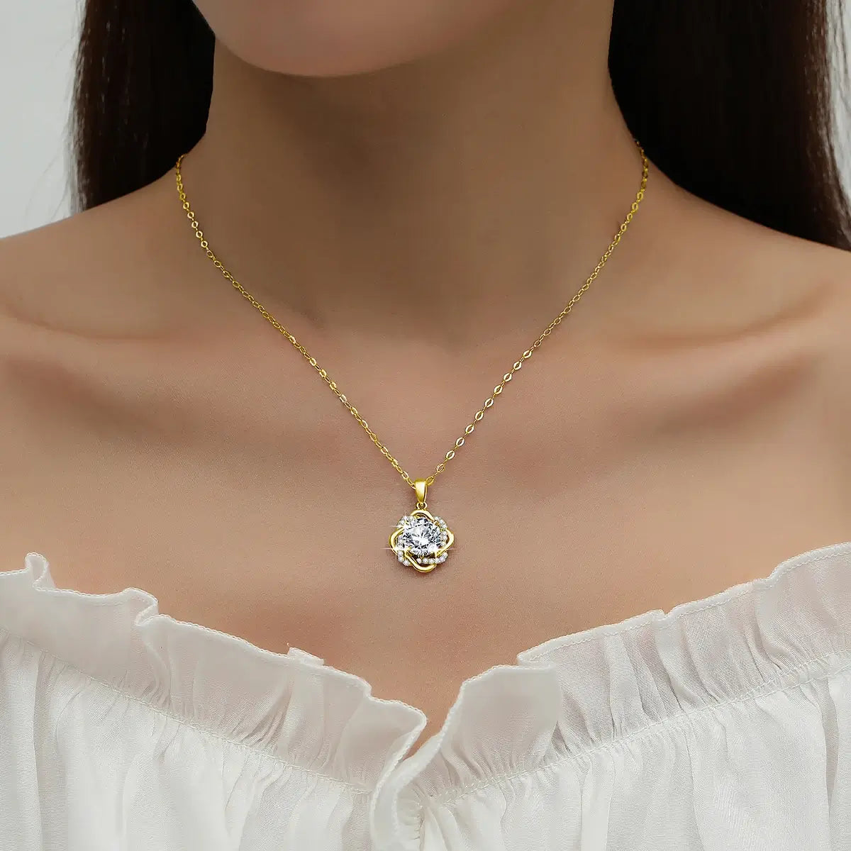 Collier fleur doré en or jaune orné d'un pendentif serti de diamants naturels en zircon et d'un diamant synthétique en moissanite porté au tour du cou d'une femme.