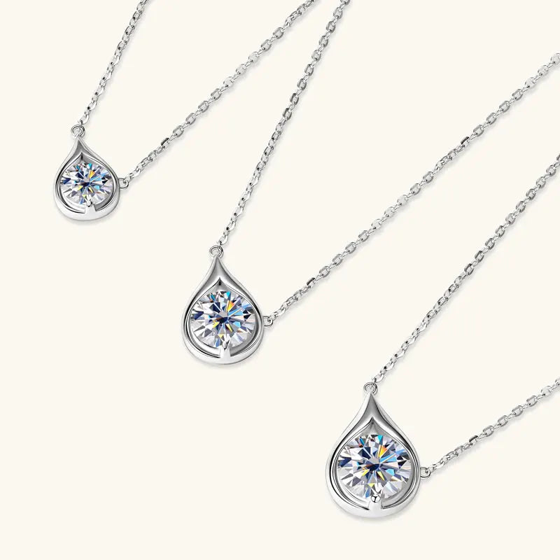 Variantes du collier pendentif goutte argenté en argent 925 plaqué or blanc et moissanite solitaire étincelante mises à plat.
