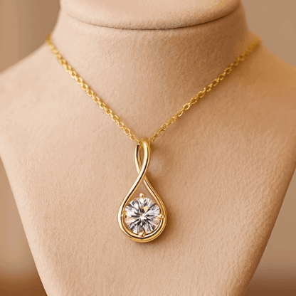 Pendentif goutte courbé Séraphin en argent 925 plaqué or jaune et diamant solitaire étincelant porté par un mannequin vue de proche.