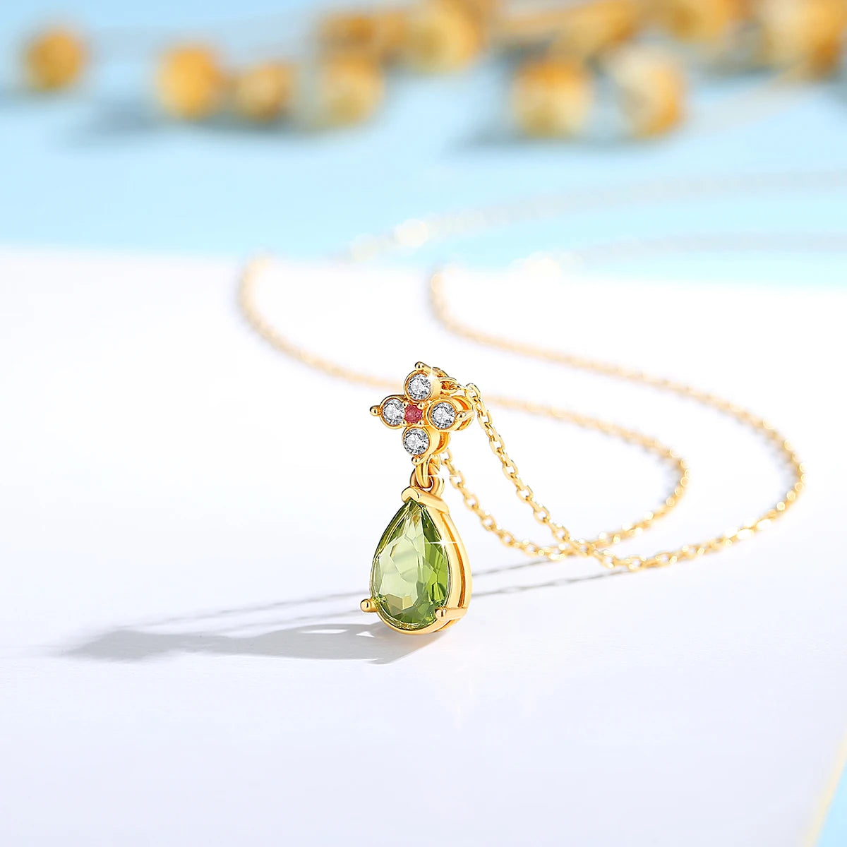 Pendentif goutte péridot Alexia en or jaune 18K orné d'un rubis envoûtant et de diamants vue de côté.