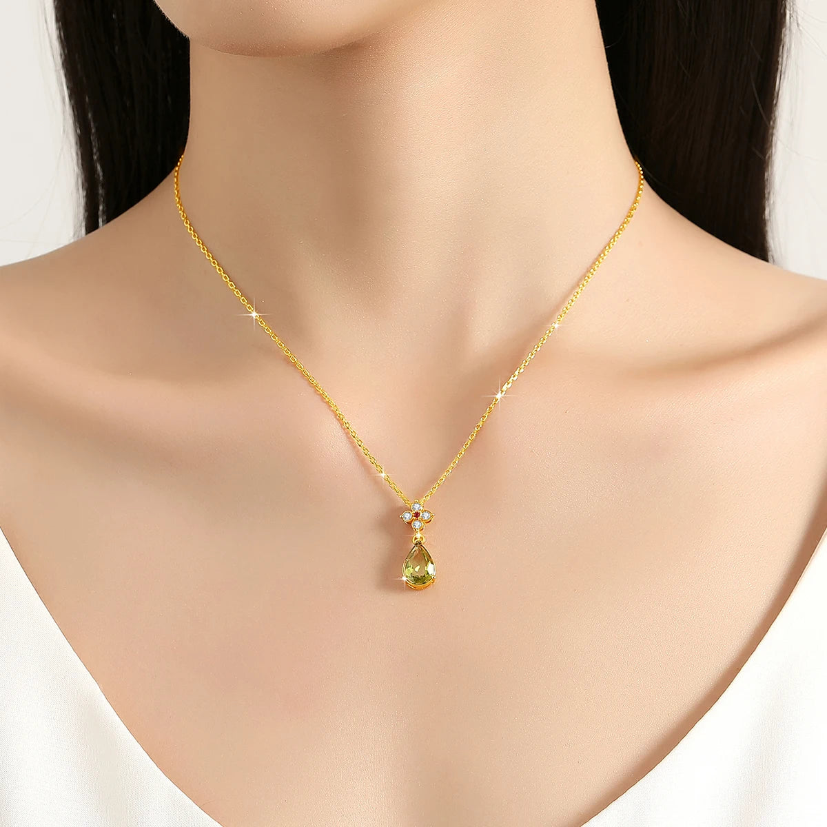Pendentif goutte péridot en or jaune, rubis et diamants naturels porté au cou d'une femme.