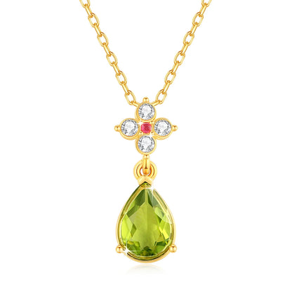 Pendentif goutte péridot en or jaune, rubis et diamants naturels sur fond blanc.