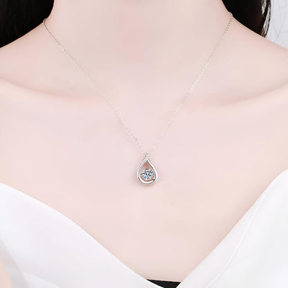 Collier goutte serti tension en or blanc orné de diamants naturels & synthétiques porté au cou d'une femme vue de proche.