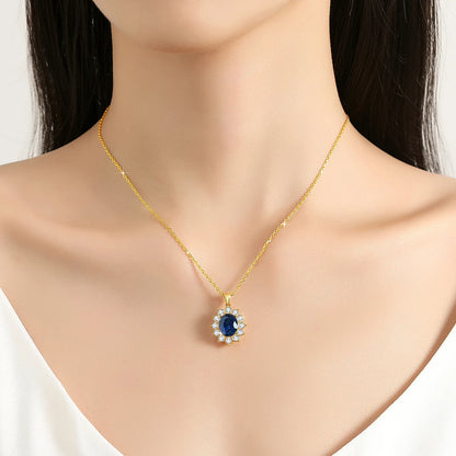 Pendentif halo saphir ovale en or jaune 18K et diamants ronds scintillants porté au cou d'une femme vue de face.