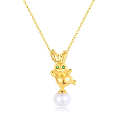 Pendentif lapin Bunny en or jaune 18K orné d'une perle ovale et de péridots verts sur fond blanc.