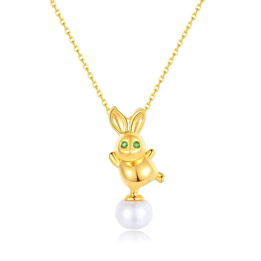 Pendentif lapin Bunny en or jaune 18K orné d'une perle ovale et de péridots verts sur fond blanc.