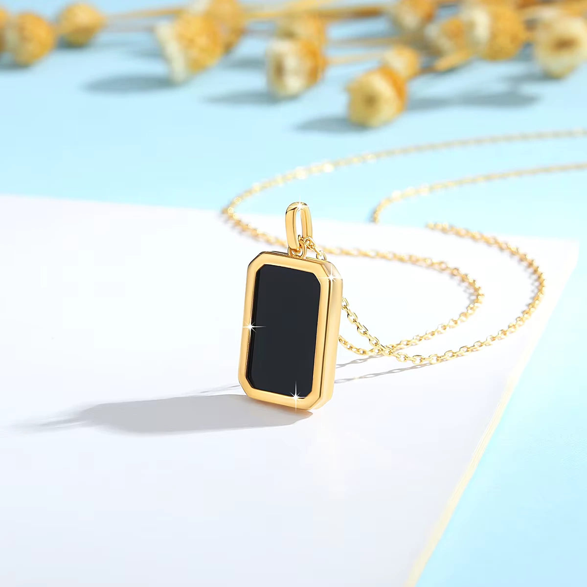 Pendentif médaillon rectangulaire Canélia en or jaune 18K rayonnant et onyx noir vue de côté.