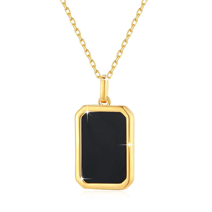 Pendentif médaillon rectangulaire en or jaune et onyx noir sur fond blanc.