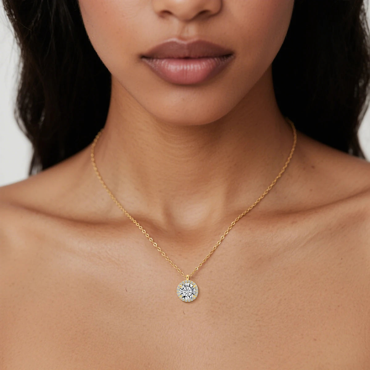 Pendentif médaillon rond Volter en or jaune 14K orné de diamants éclatants sertis quatre griffes porté au cou d'une femme vue de face.