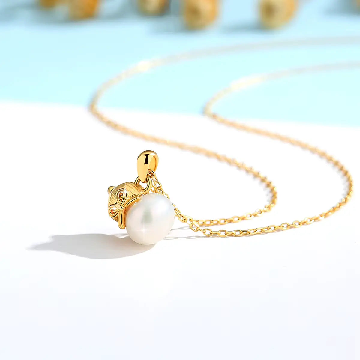 Pendentif nœud papillon Bonita en or jaune 18K éclatant et perle naturelle vue de côté.