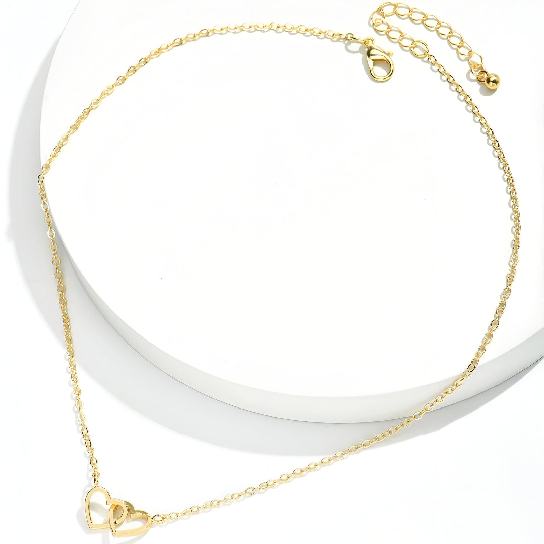 Collier pendentif fantaisie paire de cœurs en acier inoxydable plaqué or jaune étalé.