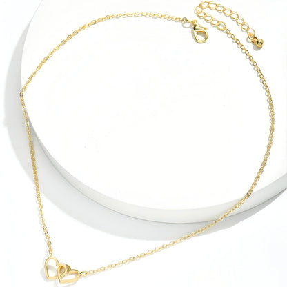 Collier pendentif fantaisie paire de cœurs en acier inoxydable plaqué or jaune étalé.