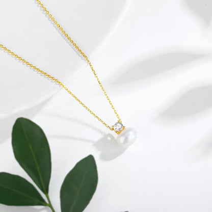 Pendentif perle solitaire nacrée Marie en or jaune 18K rayonnant et diamant serti griffes vue du dessus.