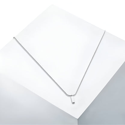 Pendentif rectangulaire en acier inoxydable et or blanc vue en gros plan.