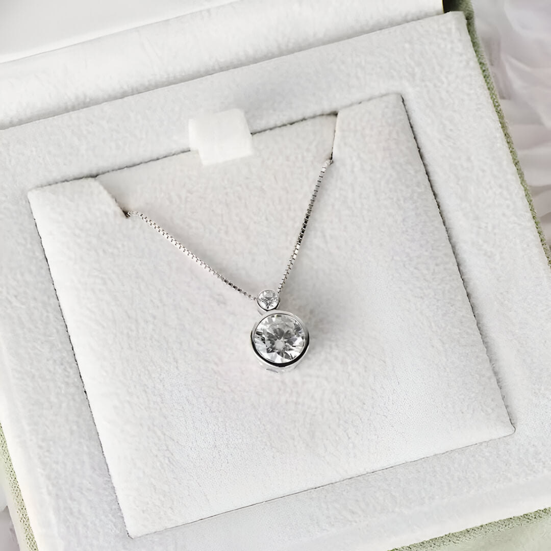 Pendentif serti clos en or blanc et diamants synthétiques dans son écrin.