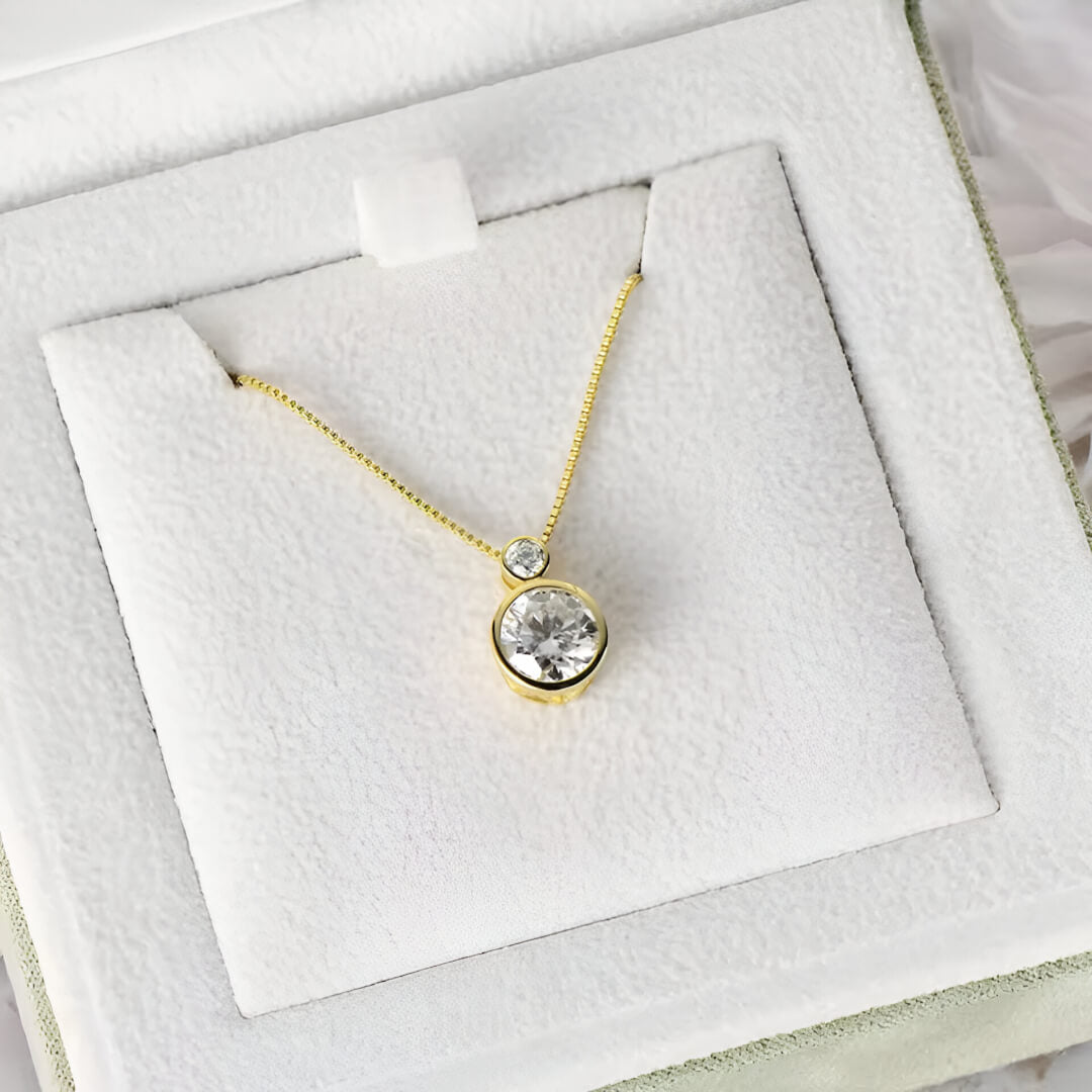 Pendentif serti clos en or jaune et diamants synthétiques dans son écrin.