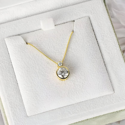 Pendentif serti clos en or jaune et diamants synthétiques dans son écrin.