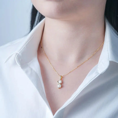Pendentif courbé serti invisible en or jaune et diamants synthétiques porté au cou d'une femme.