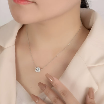 Pendentif solaire en or blanc et diamants synthétiques porté au cou d'une femme.