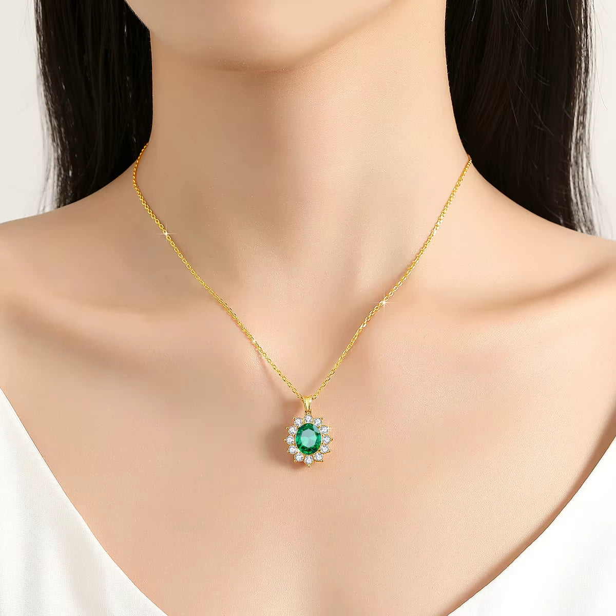 Pendentif solaire émeraude ovale Xanthin en or jaune 18K chaleureux et diamants porté au cou d'une femme.