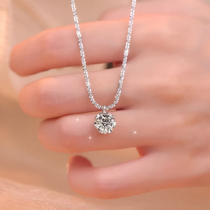 Pendentif solitaire 6 griffes en or blanc et diamants synthétiques montré par une main de femme.