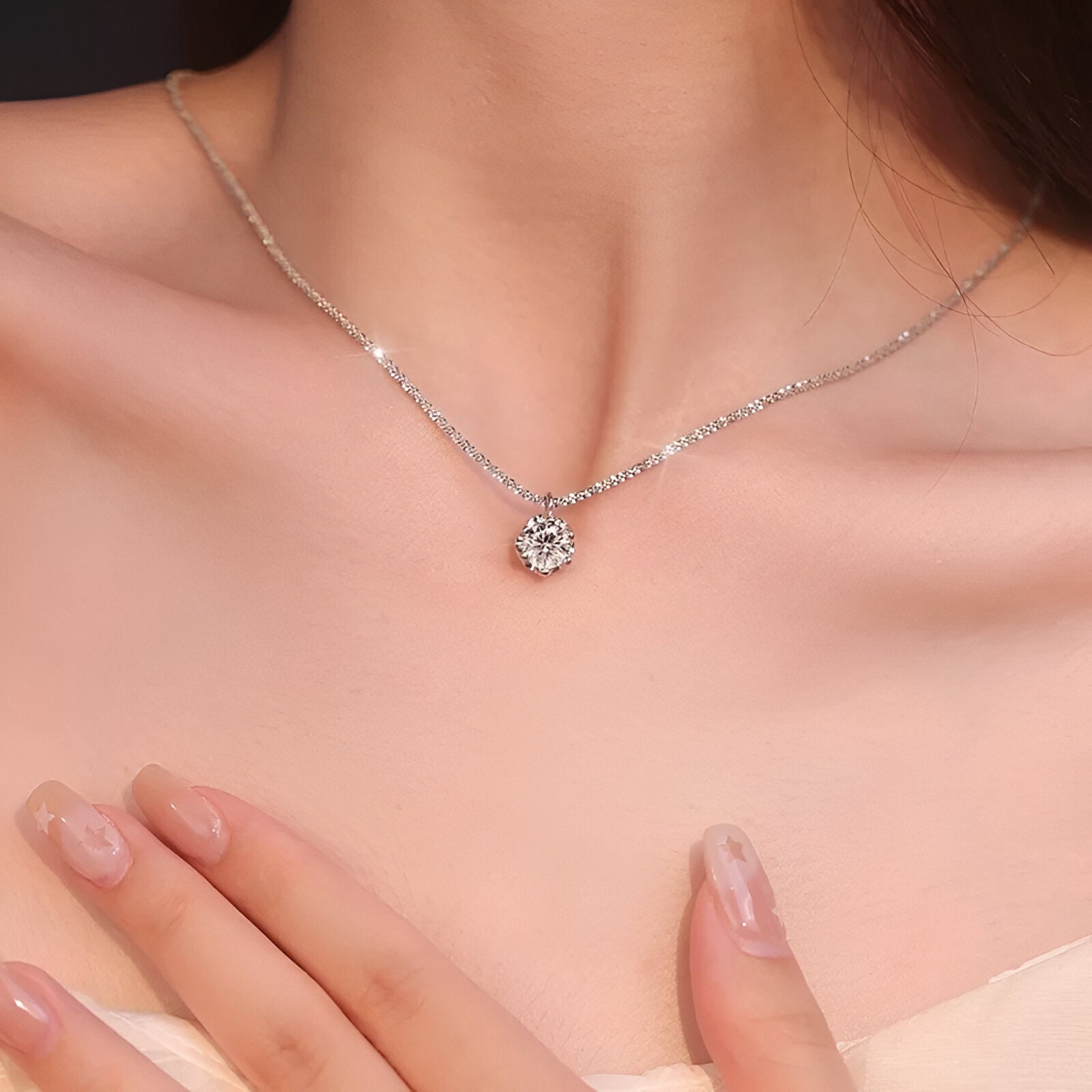 Pendentif solitaire 6 griffes en or blanc et diamants synthétiques porté au cou d'une femme vue rapprochée.