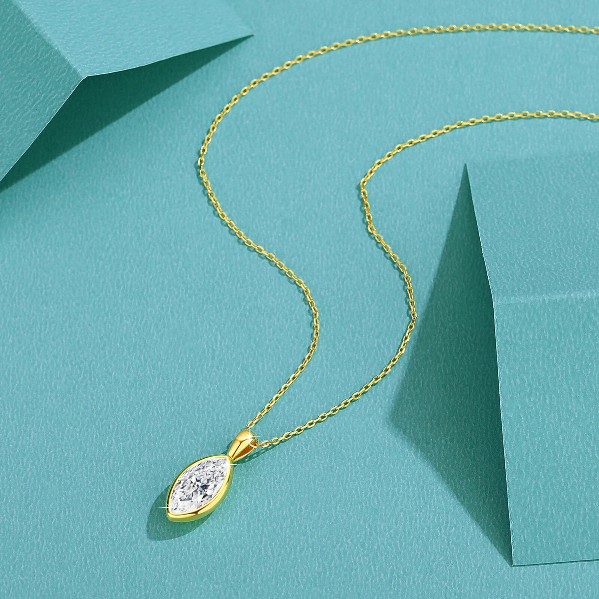 Pendentif solitaire diamant étincelant taille navette serti clos Mathéys en or jaune 14K à plat.