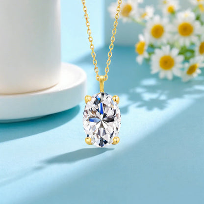 Pendentif solitaire diamant ovale serti quatre griffes Maelys en or jaune 14K rayonnant vue de proche.