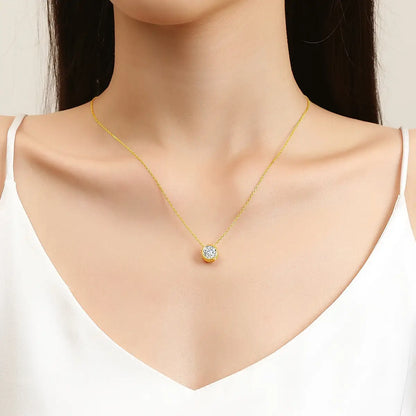 Pendentif solitaire Naélie en or jaune 18K et diamant rond porté au cou d'une femme vue de face.