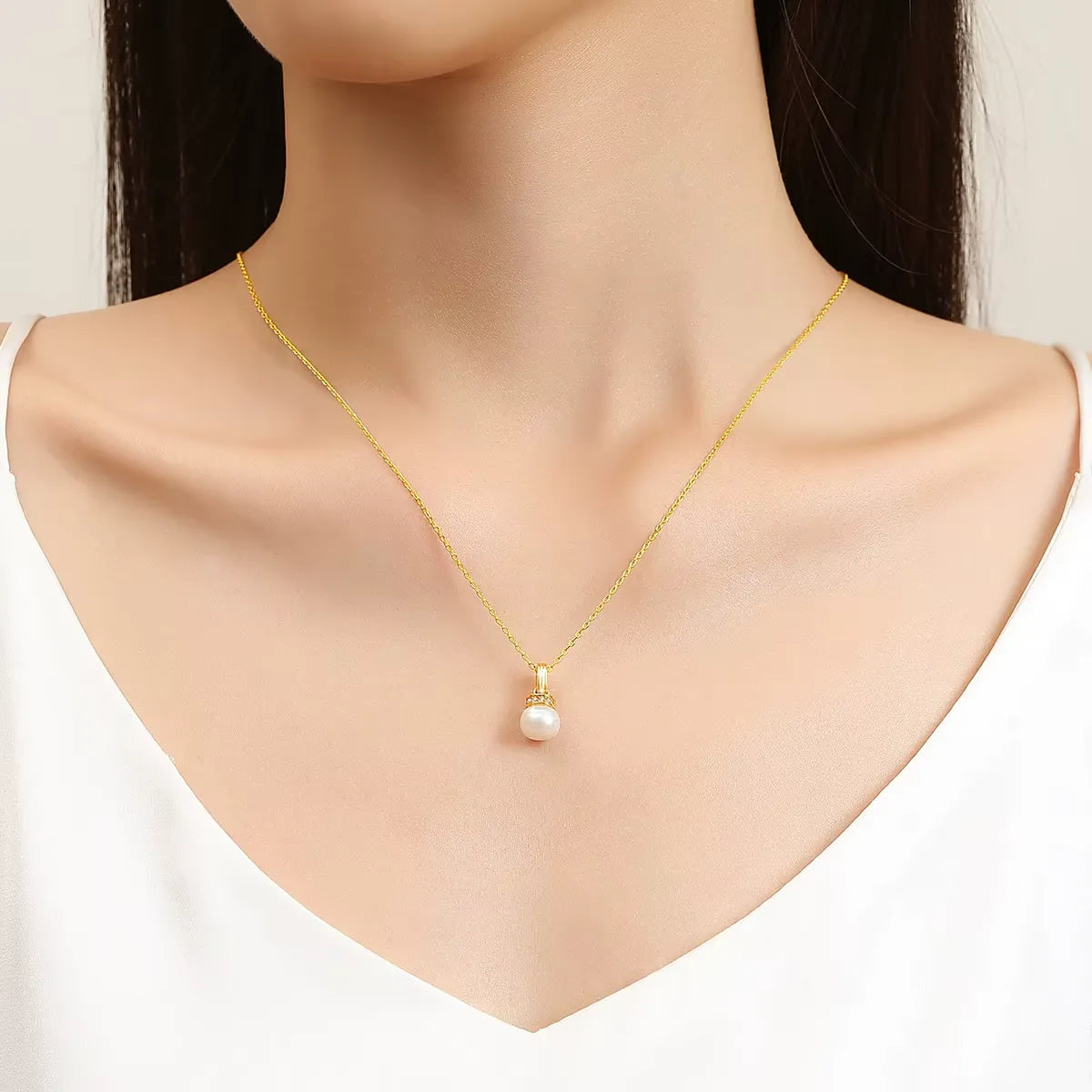 Pendentif solitaire perlé en or jaune et diamants naturels porté au cou d'une femme.