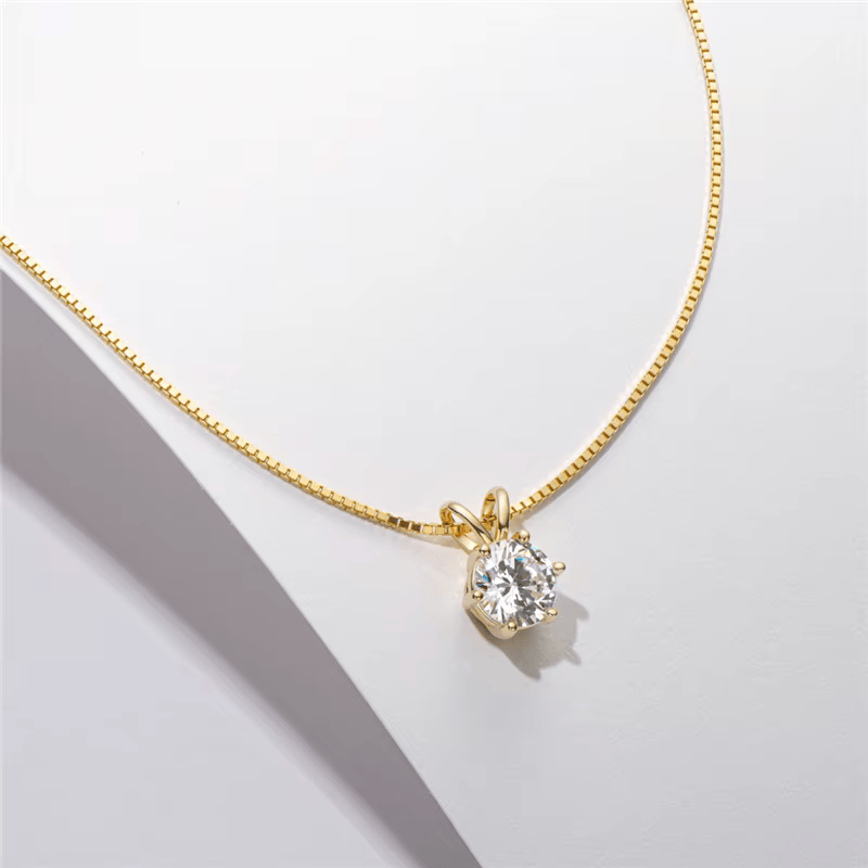 Collier pendentif solitaire en or jaune et diamant synthétique posé.