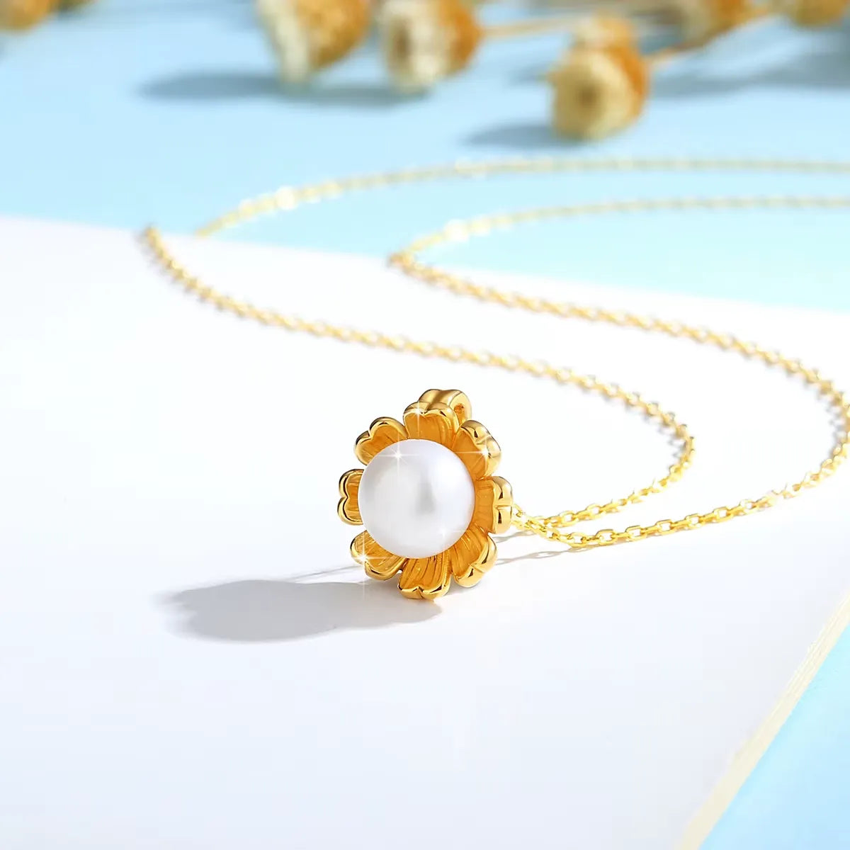 Pendentif fleur de tournesol Florina en or jaune 18K lumineux et perle nacrée vue de côté.