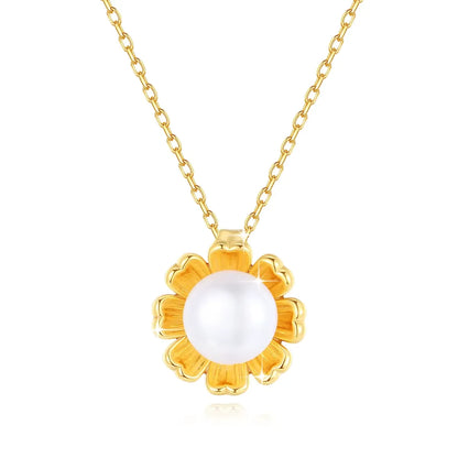 Pendentif fleur de tournesol Florina en or jaune 18K et perle nacrée sur fond blanc.