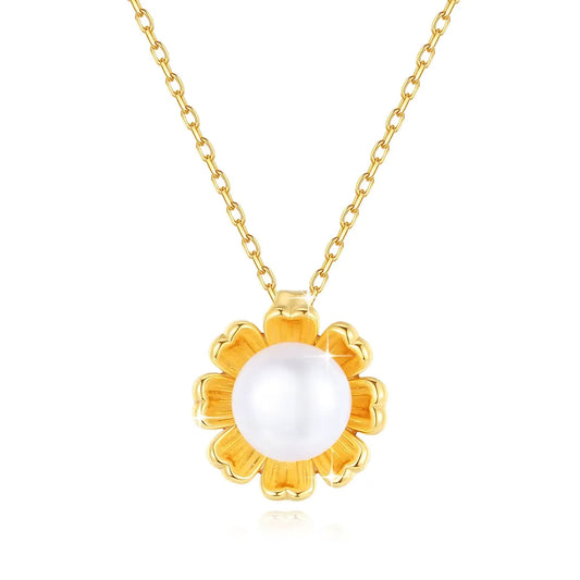 Pendentif fleur de tournesol en or jaune et perle nacrée sur fond blanc.