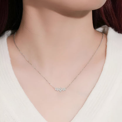 Pendentif trio de fleurs en argent 925 plaqué or blanc et diamants brillants porté au cou d'une femme vue de face.