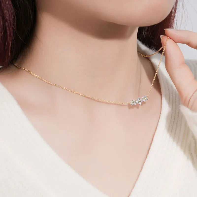 Pendentif triple trèfle Rosalia en argent 925 plaqué or jaune et diamants porté au cou d'une femme vue de côté.