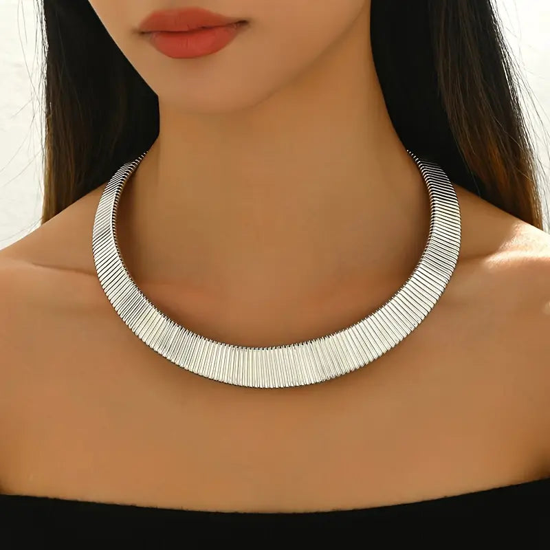 Collier choker torque en or blanc porté au cou d'une femme vue de face.